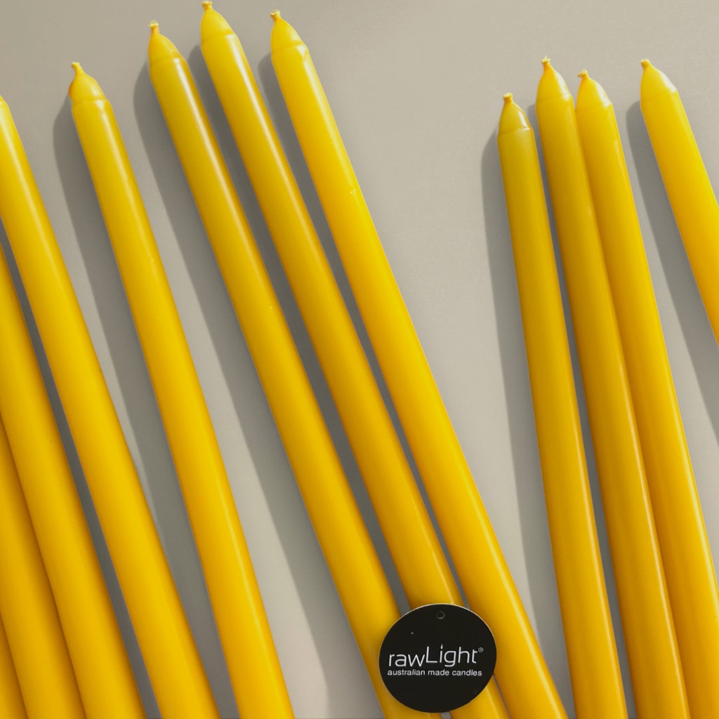 rawLight Coloured Taper Candles yellow slender taper candles in a row